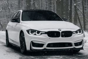 European auto repair in Long Lake, MN at Arvu Auto. Image of a white BMW driving on a snow-covered road, highlighting seasonal maintenance for safe, reliable cold-weather performance.
