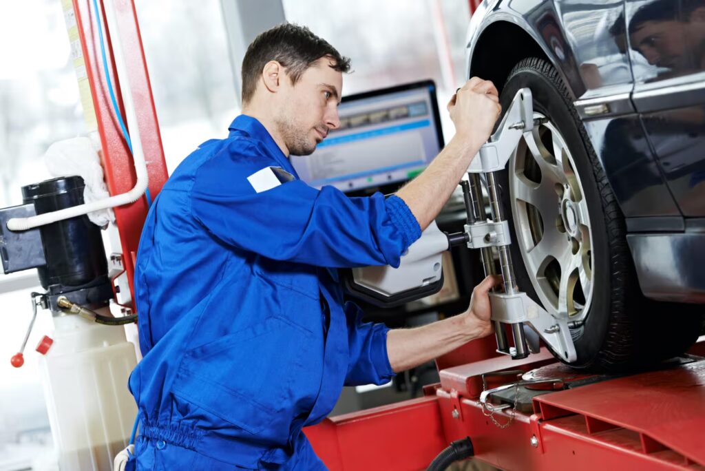 a mechanic working on a car wheel alignment