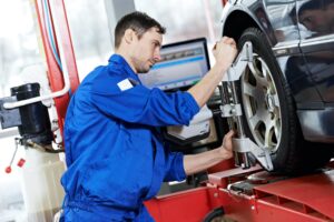 a mechanic working on a car wheel alignment