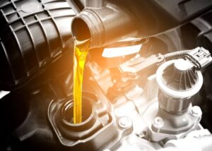 Oil being poured into an engine tank during maintenance service.