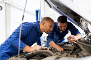 Two mechanics working on a car's engine
