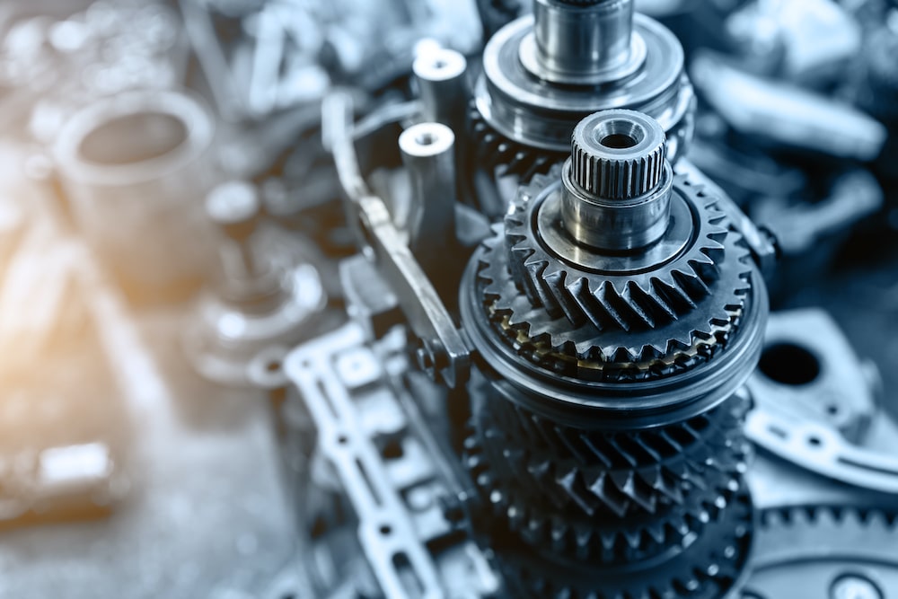 Closeup disassembled car automatic transmission gear part on workbench at garage or repair factory station for fix service or maintenance. Vehicle part detail. Complex industrial mechanism background