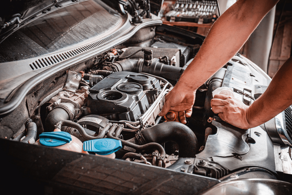 car care, auto repair in Long Lake, MN at Arvu Auto. Image of a mechanic checking engine oil levels with a dipstick.