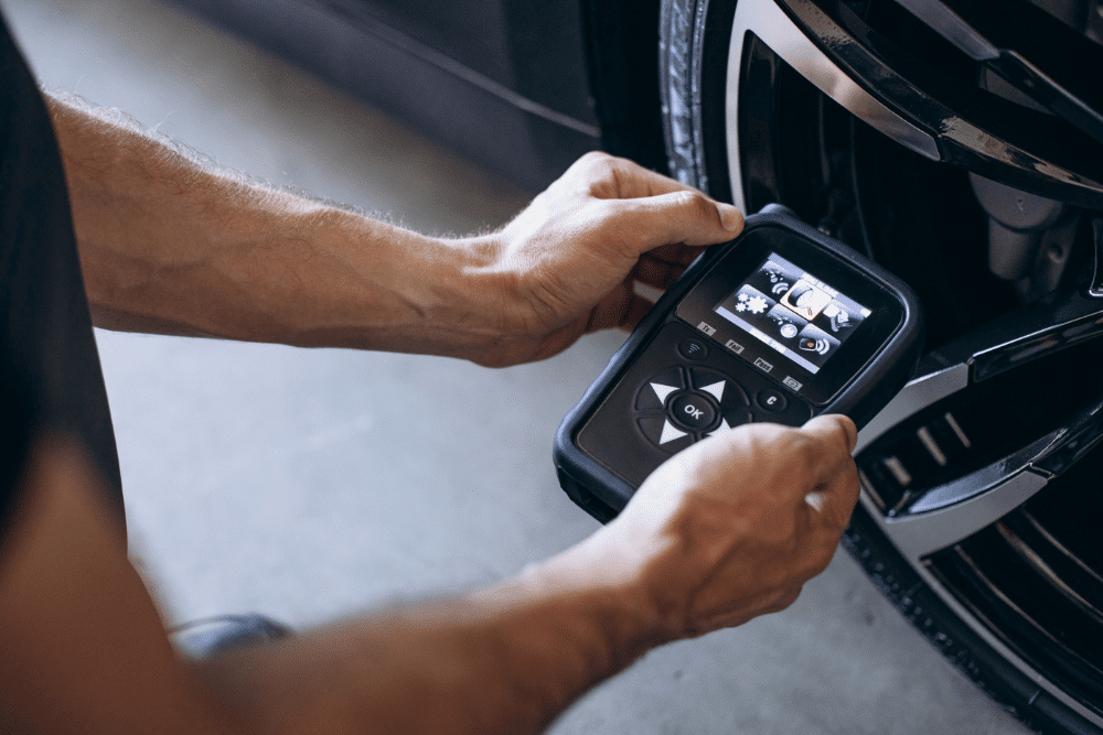 Tire pressure check, auto repair in Long Lake, MN by Arvu Auto. Image of a technician using a TPMS diagnostic tool near a vehicle’s wheel. Highlighting Arvu Auto’s commitment to accurate tire pressure monitoring and safe driving performance.