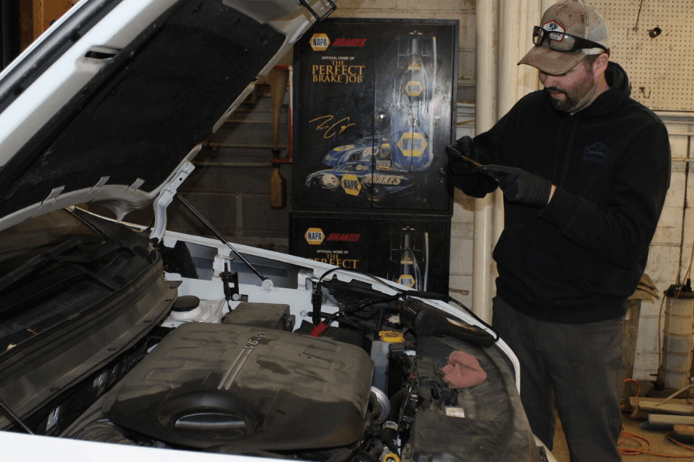 Engine diagnostics, auto repair in Cokato, MN by Arvu Auto. Image of a technician inspecting a vehicle engine while using digital tools for accurate diagnostics, ensuring reliable performance, preventative maintenance, and high-quality automotive care.