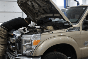 Car parts, auto repair in Long Lake, MN at Arvu Auto. Image of a technician performing diagnostics and engine repair on a Ford F-350 Super Duty to maintain reliable diesel performance, towing capability, and heavy-duty truck dependability.