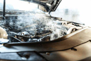 Car overheating, auto repair in Watertown, MN, at Arvu Auto. Image of a steam rising from an overheated vehicle engine with the hood open, illustrating engine overheating caused by cooling system problems that require immediate diagnosis and repair.