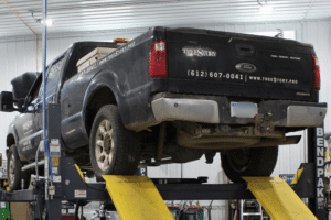 Local fleet maintenance in Watertown, MN, at Arvu Auto. Image of a commercial Ford work truck on a lift during fleet maintenance service, highlighting preventative maintenance that maximizes uptime, improves reliability, and keeps business vehicles operating safely.